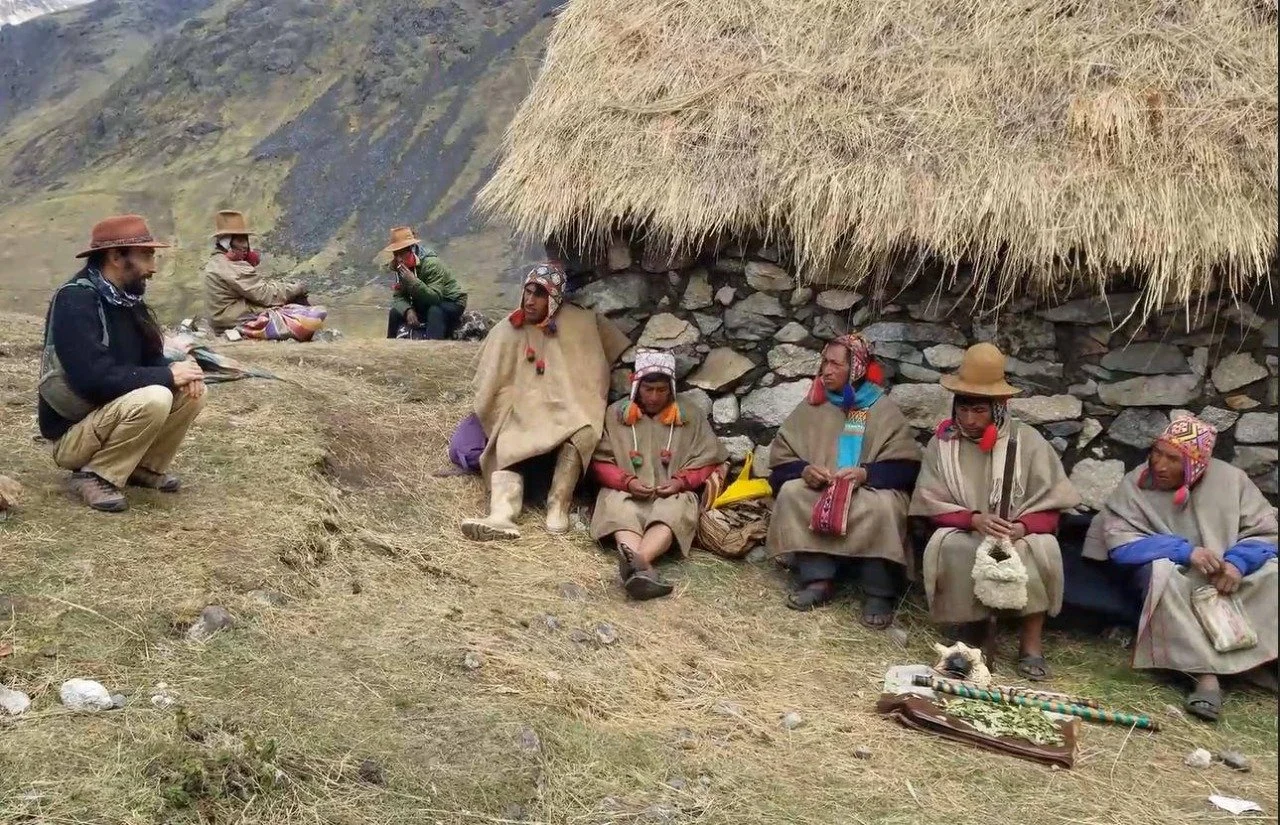 Q'ero community elders gathered outside a stone dwelling in the Andes