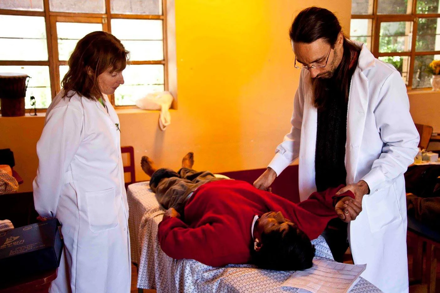 Roman Hanis and a practitioner treating a patient at a free Natural Medicine clinic in the Andes