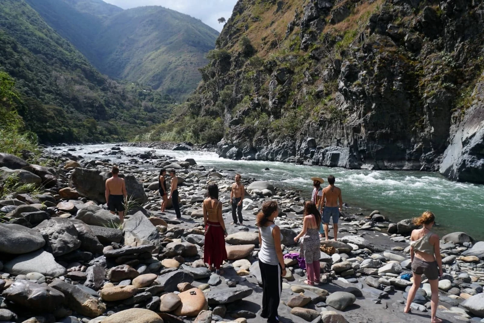 Un grupo descansando en la orilla llena de cantos rodados del río Mapacho, al pie de la reserva