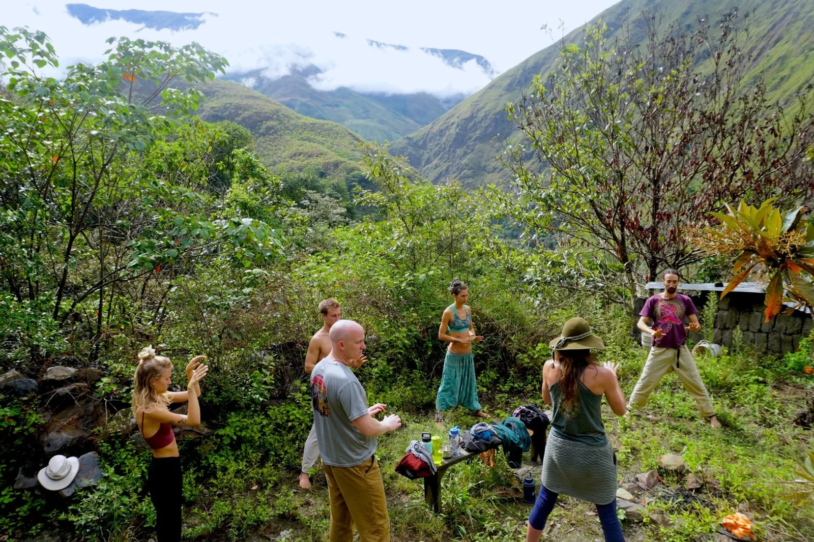 Un grupo practicando Qigong sobre una terraza de pasto con vista al valle